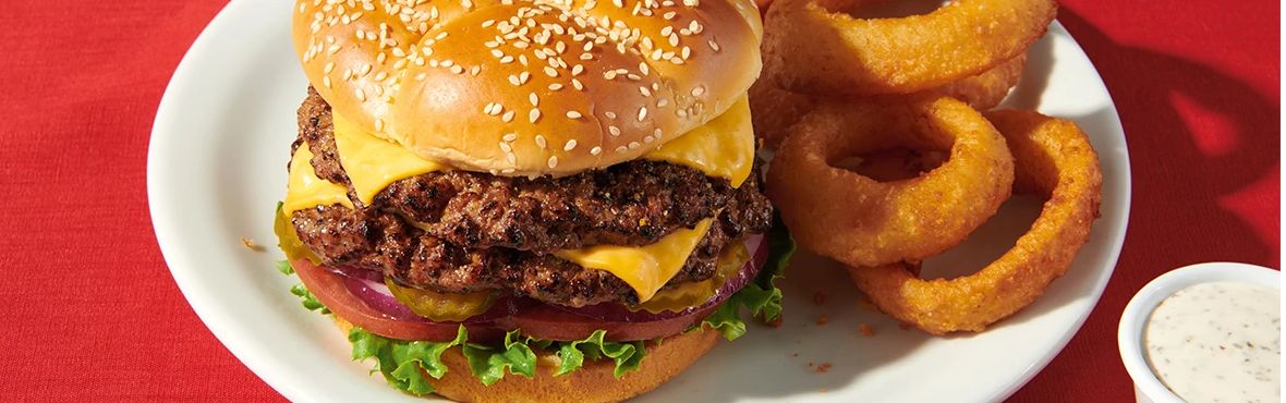 double cheeseburger with lettuce, onion, tomato, pickle and onion rings