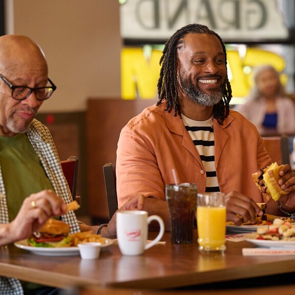 Dos hombres comiendo en Denny's