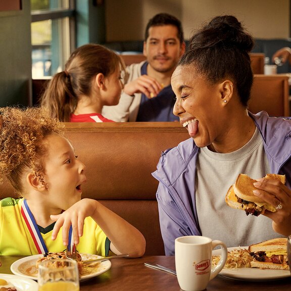 Madre e hija comiendo en Denny's