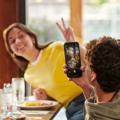 Dos invitados con su teléfono en un restaurante