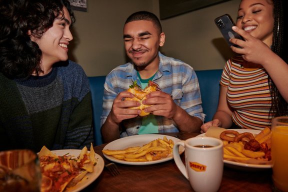 Group of young adults eating at a table.