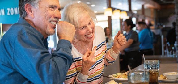 Older couple laughing at a table