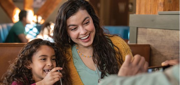 Mom and child smiling at a table