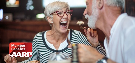 Older couple laughing at a table