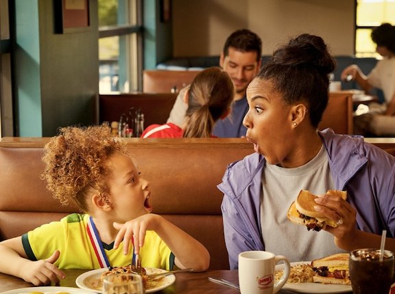 The woman and her child look thrilled as they eat their meal